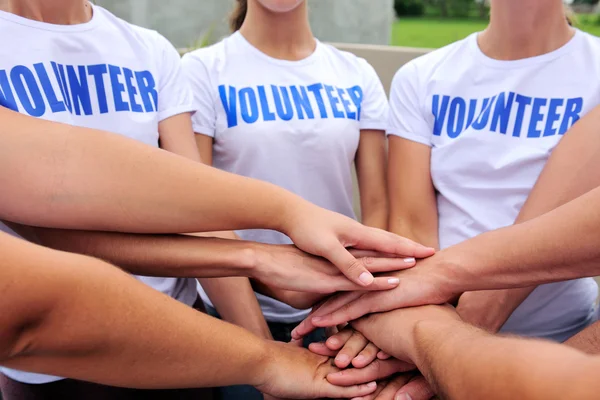Smiling volunteers standing with their arms around each other